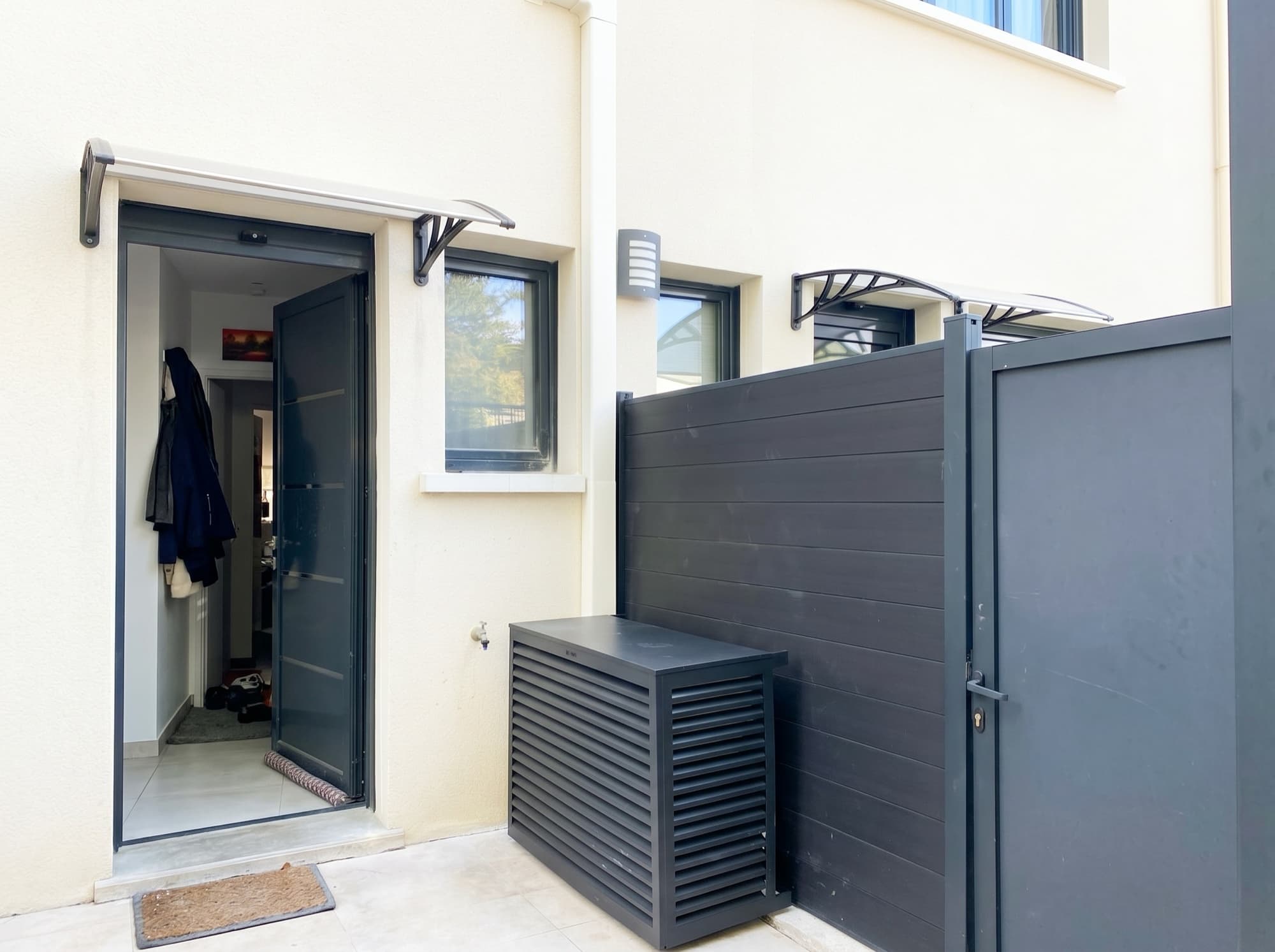 Groupe extérieur de climatisation dissimulé derrière un cache